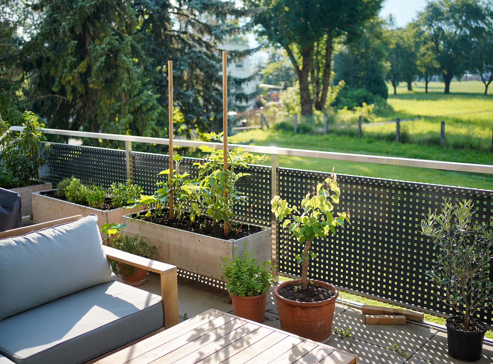 Hochbeete auf Balkon, Terrasse oder im Garten - bei uns finden Sie die passenden Ausfürungen Sicht auf Terrasse mit bepflanztem Hochbeet